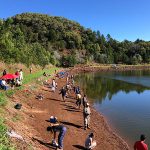 Crowds of people fishing for trout in a reservoir