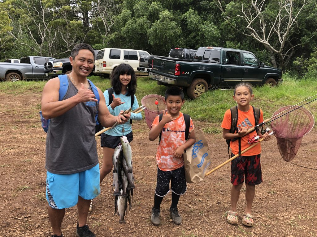 A family shows of the fish they just caught