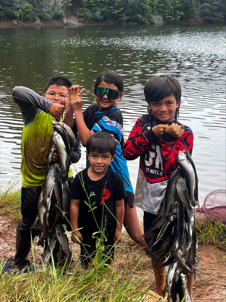 A group of boys holding up a stringer of rainbow trout